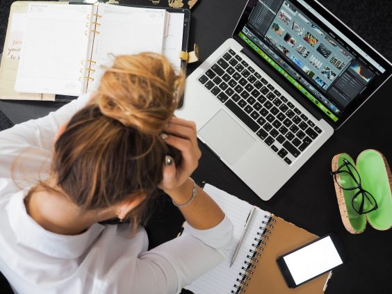 Woman at computer with head in her hands