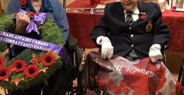 Female veterans at Holy Family (L to R): Penny Sitrling, Colleen de Serres and Geraldine Grimway. The three women are sitting in front of a Remembrance Day display.