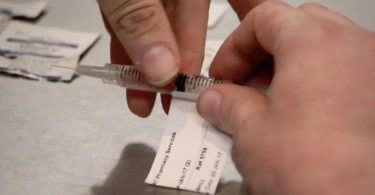 A patient at the Crosstown Clinic in Vancouver's Downtown Eastside prepares one of his three daily doses of prescribed hydromorphone in January, 2017. (Rafferty Baker/CBC)