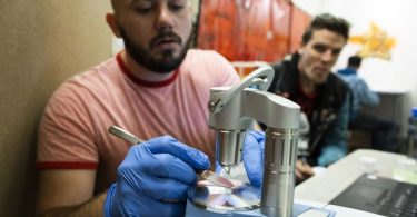 Kyle Besaw, left, drug checking tech aid with Vancouver Coastal Health, and Trey Helten, right, supervisor at the Overdose Prevention Society safe injection site, check samples of heroin for fentanyl and other substances in Vancouver, British Columbia, July 11, 2019. (Photo Credit: RAFAL GERSZAK/THE GLOBE AND MAIL)