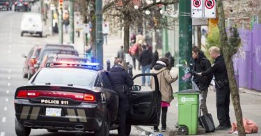 Police speak to a man and woman on East Hastings in Vancouver's Downtown Eastside, Thursday, Feb 7, 2019. (THE CANADIAN PRESS/Jonathan Hayward)