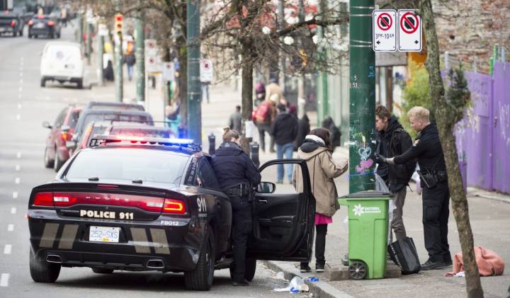 Police speak to a man and woman on East Hastings in Vancouver's Downtown Eastside, Thursday, Feb 7, 2019. (THE CANADIAN PRESS/Jonathan Hayward)