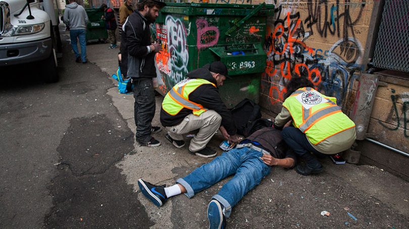 Staff members from the popup safe injection tent prepare the insect a man with Naloxone as he overdoses in a Downtown Eastside alley in Vancouver, British Columbia, November 18, 2016. (Photo Credit: Rafal Gerszak)