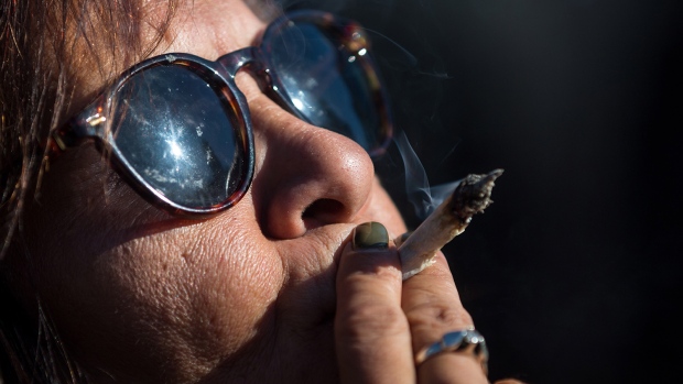 A woman smokes marijuana while celebrating the legalization of recreational cannabis, in Vancouver (Photo credit: CTV News).