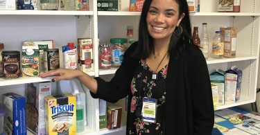 Melodee Dayrit standing in front of shelves with food displays