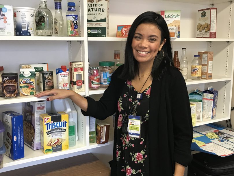 Melodee Dayrit standing in front of shelves with food displays