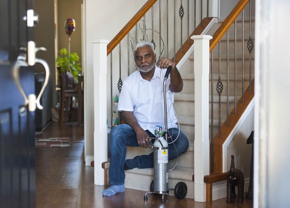Atish Ram with an oxygen machine inside his Surrey home. (Photo credit: Vancouver Sun)