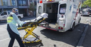 Paramedics respond to an emergency medical call in the 100-block E. Hastings Street in Vancouver. (Photo Credit: Vancouver Sun)