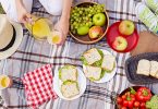 Picnic set-up on blanket, with fruit and sandwiches