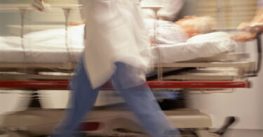 Doctors pushing patient on trolley